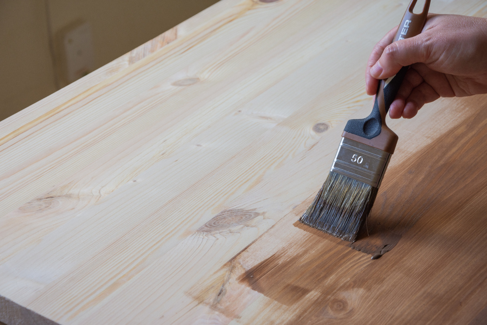 Worktop Refinishing in Bracknell on a pine kitchen worktop with stain being applied beside engineered oak flooring